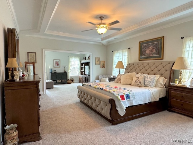 bedroom featuring ceiling fan, light carpet, a raised ceiling, and crown molding