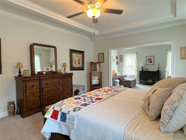 bedroom with ceiling fan, light carpet, a raised ceiling, and crown molding