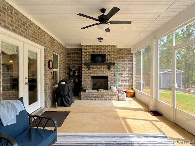 sunroom / solarium with ceiling fan and an outdoor brick fireplace