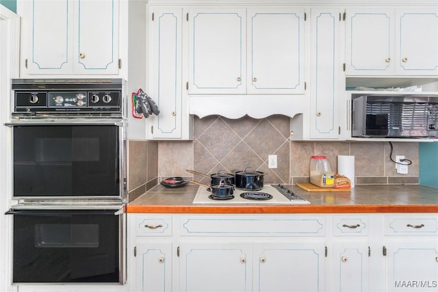 kitchen with double oven, white cabinetry, tasteful backsplash, and white gas stovetop