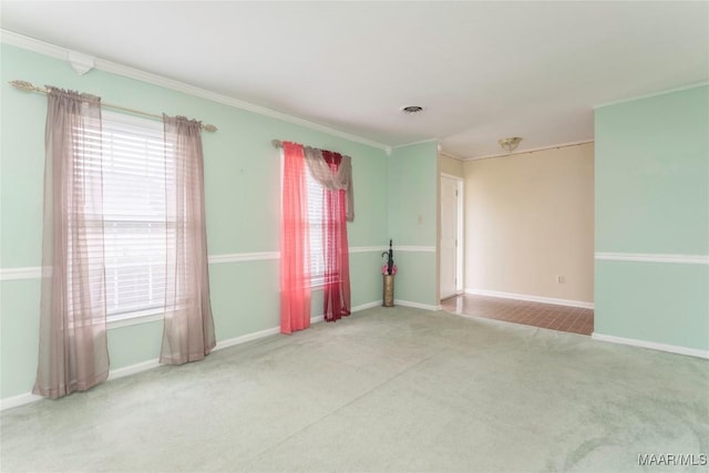 spare room featuring a wealth of natural light, crown molding, and carpet