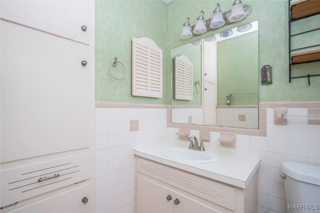 bathroom with vanity, toilet, and tile walls