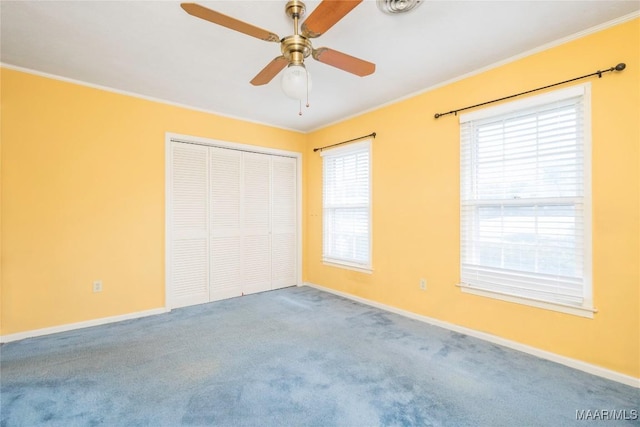 unfurnished bedroom featuring multiple windows, ceiling fan, a closet, and ornamental molding