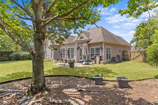 back of house with a patio and a lawn