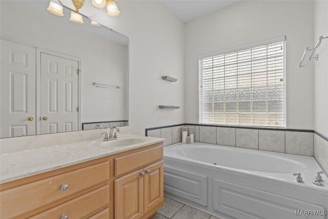 bathroom with tile patterned flooring, a tub, and vanity