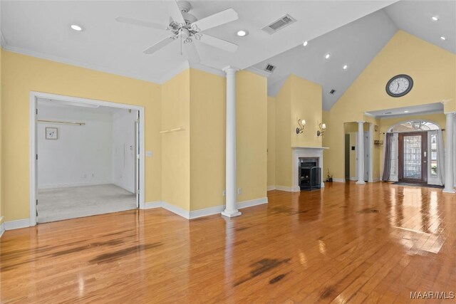 unfurnished living room featuring ceiling fan, light wood-type flooring, and ornate columns