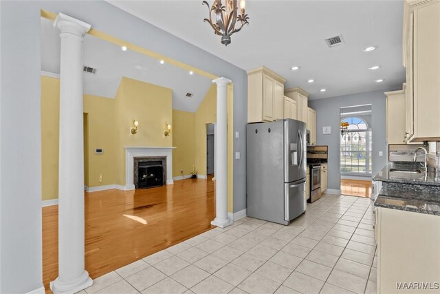 kitchen featuring light hardwood / wood-style flooring, appliances with stainless steel finishes, sink, dark stone countertops, and a high end fireplace