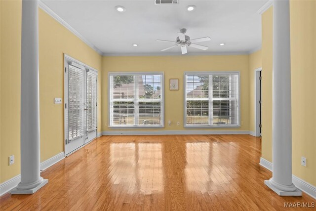 interior space with ceiling fan, light hardwood / wood-style floors, ornamental molding, and ornate columns