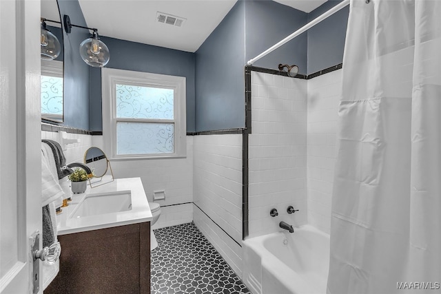 full bathroom featuring toilet, vanity, shower / bath combo, tile patterned floors, and tile walls