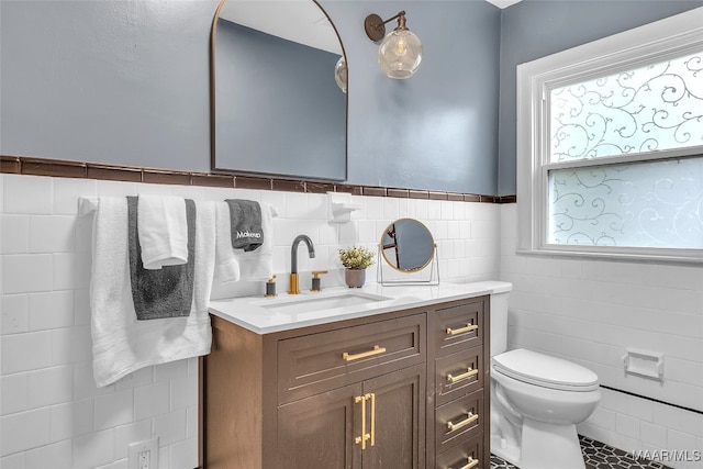 bathroom with backsplash, vanity, tile patterned floors, tile walls, and toilet