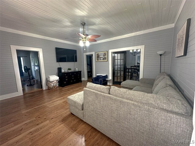 living room with hardwood / wood-style flooring, ornamental molding, ceiling fan with notable chandelier, and wood ceiling