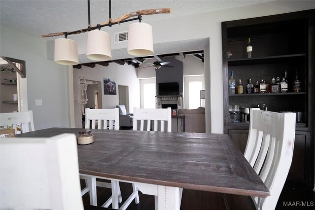 dining room with ceiling fan, track lighting, and a textured ceiling