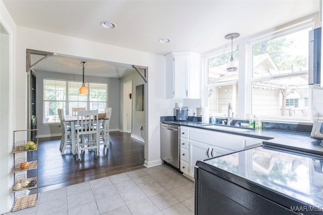 kitchen featuring light tile patterned floors, a wealth of natural light, sink, and white cabinets