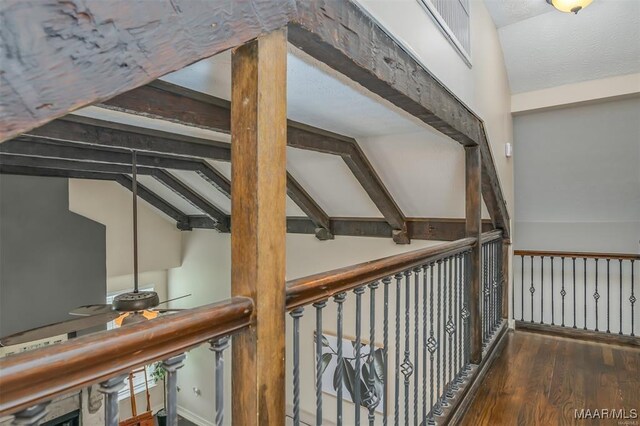 hallway featuring hardwood / wood-style flooring and vaulted ceiling with beams