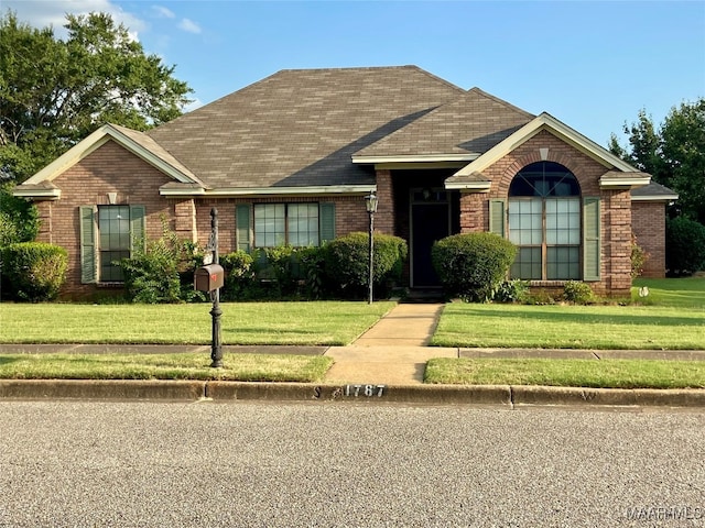 single story home featuring a front lawn