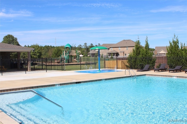 view of swimming pool featuring a playground and a patio