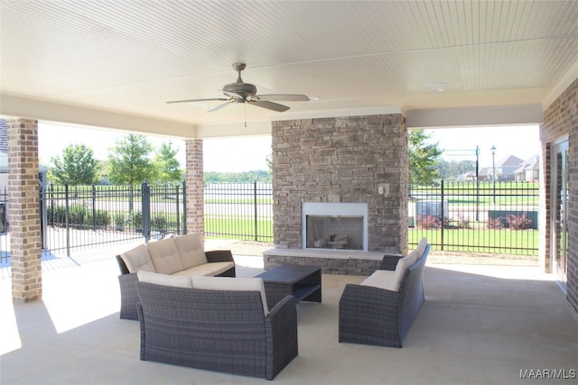 view of patio / terrace featuring ceiling fan and an outdoor living space with a fireplace