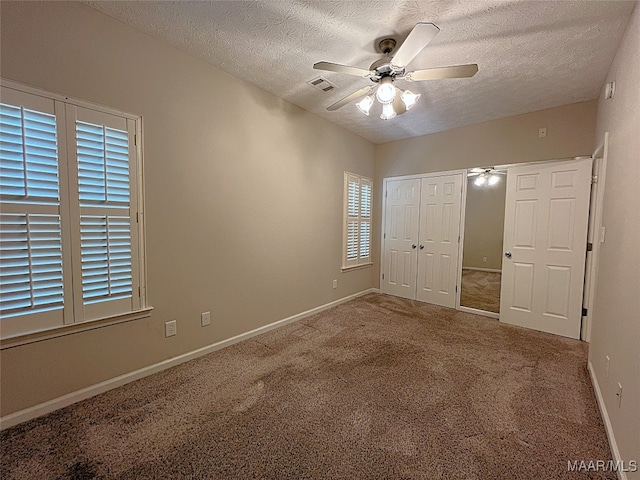 unfurnished bedroom with ceiling fan, a closet, carpet floors, and a textured ceiling