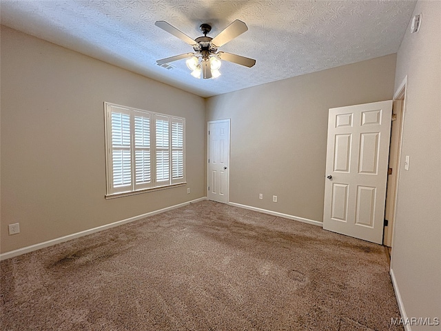 spare room with carpet, a textured ceiling, and ceiling fan