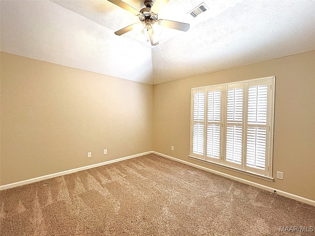 carpeted spare room with ceiling fan, lofted ceiling, and a textured ceiling