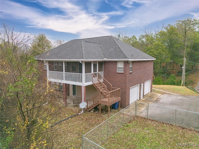 rear view of property featuring a garage and a sunroom