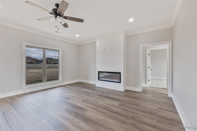 unfurnished living room with ceiling fan, a fireplace, hardwood / wood-style floors, and ornamental molding