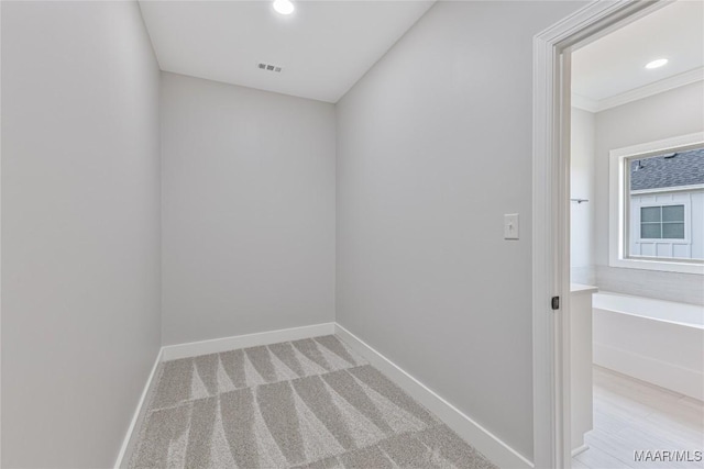 empty room with crown molding and light carpet