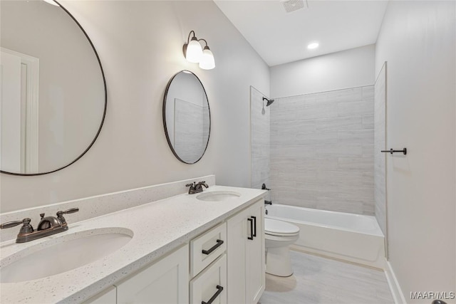 full bathroom with vanity, toilet, and tiled shower / bath