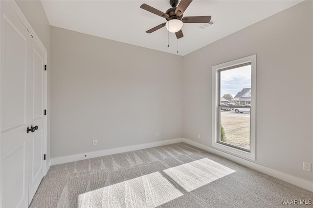 carpeted empty room featuring ceiling fan and a wealth of natural light