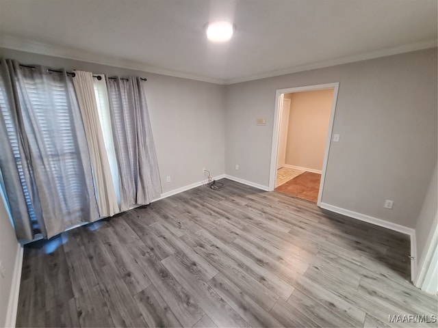 unfurnished room with ornamental molding and wood-type flooring