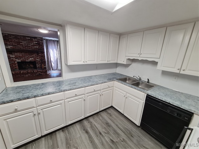 kitchen featuring light wood-type flooring, white cabinetry, sink, a fireplace, and black dishwasher