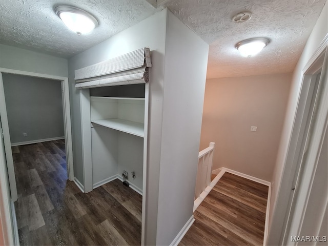 hallway with a textured ceiling and wood-type flooring