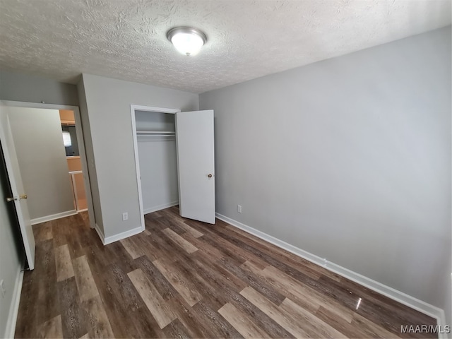 unfurnished bedroom featuring a closet, a textured ceiling, and hardwood / wood-style floors