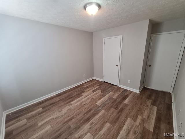 unfurnished bedroom with hardwood / wood-style flooring and a textured ceiling