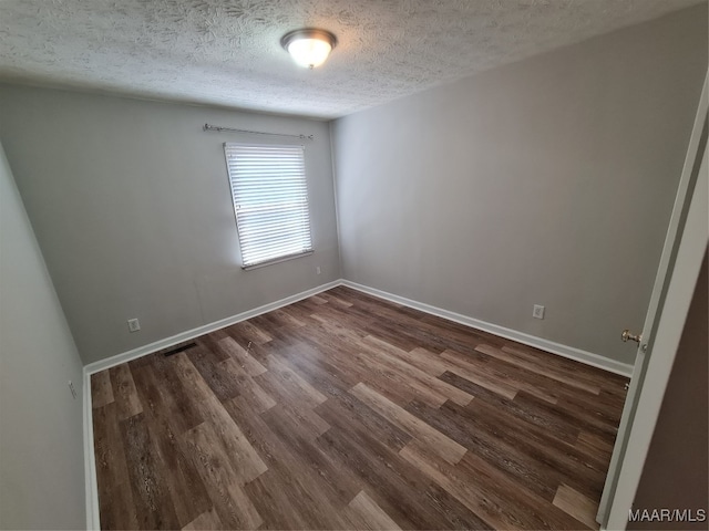 empty room featuring hardwood / wood-style flooring and a textured ceiling