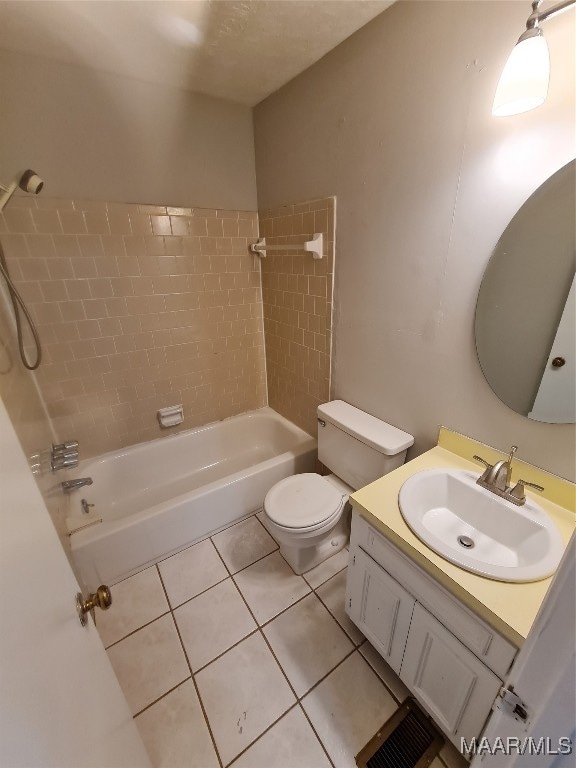 full bathroom featuring tile patterned floors, toilet, tiled shower / bath, and vanity