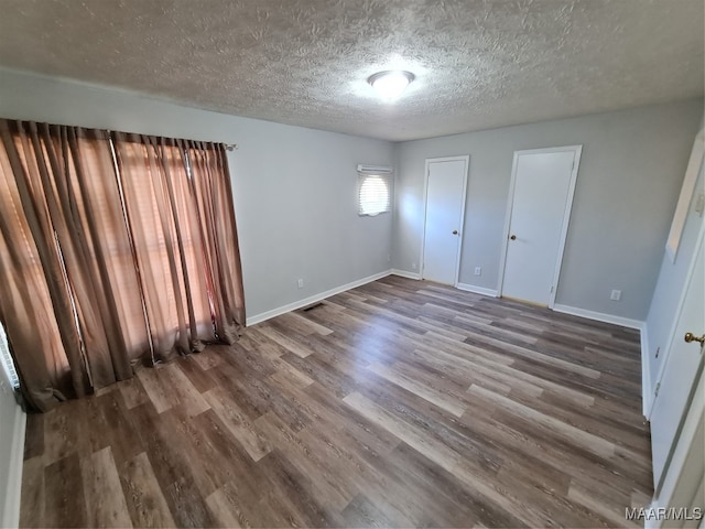 interior space with a textured ceiling and hardwood / wood-style flooring