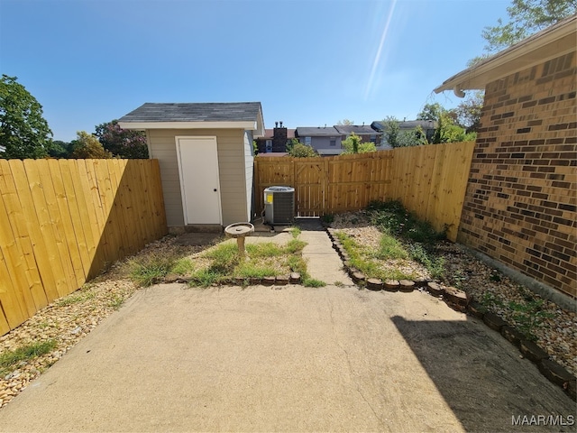 view of yard with a storage unit, central AC, and a patio area