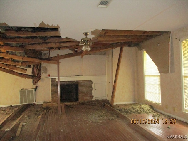 interior space with ceiling fan, hardwood / wood-style floors, and a brick fireplace