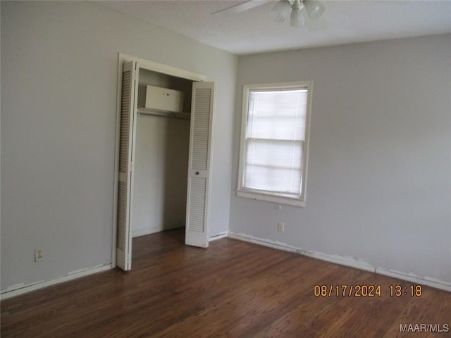 unfurnished bedroom featuring ceiling fan, a closet, and dark wood-type flooring