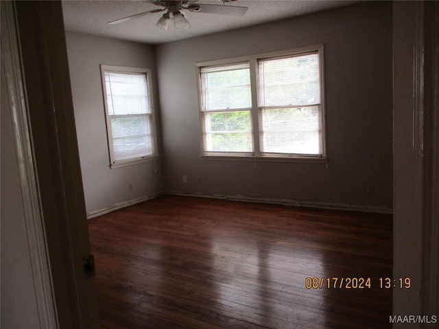 spare room featuring ceiling fan and dark wood-type flooring