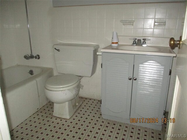 bathroom with backsplash, vanity, tile patterned flooring, tile walls, and toilet