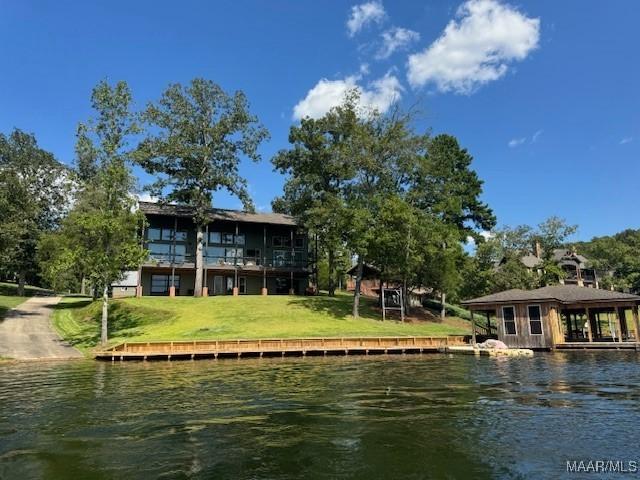 rear view of house with a lawn and a water view