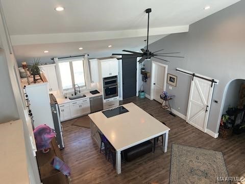 kitchen featuring lofted ceiling with beams, dark wood-type flooring, white cabinets, and light countertops