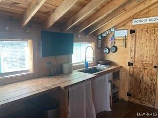 kitchen featuring wooden ceiling, vaulted ceiling with beams, light countertops, blue cabinetry, and a sink