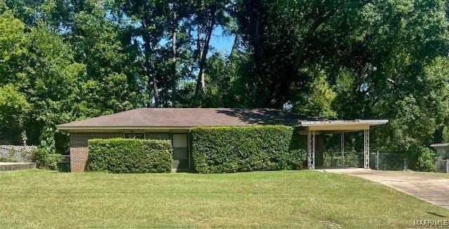 view of front of house with a front yard, concrete driveway, brick siding, and an attached carport