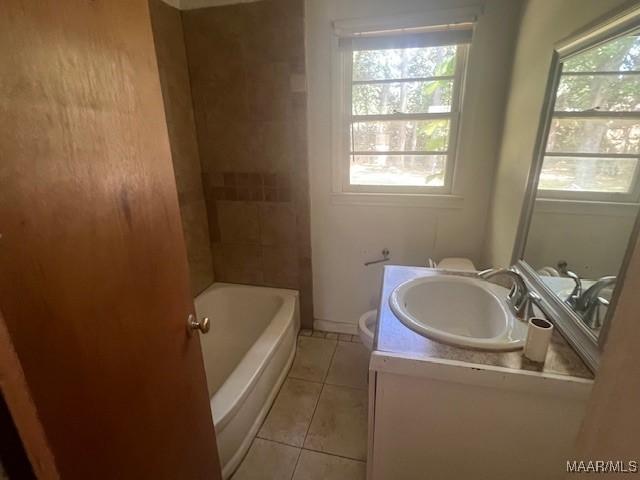 full bathroom with toilet, tiled shower / bath combo, vanity, and tile patterned floors