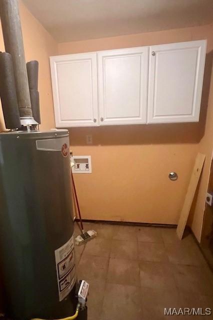 clothes washing area with gas water heater, light tile patterned floors, washer hookup, and cabinets