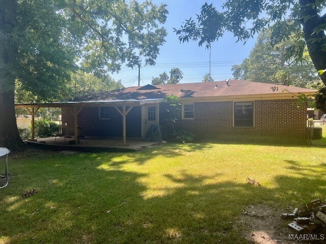 back of house with a patio and a yard