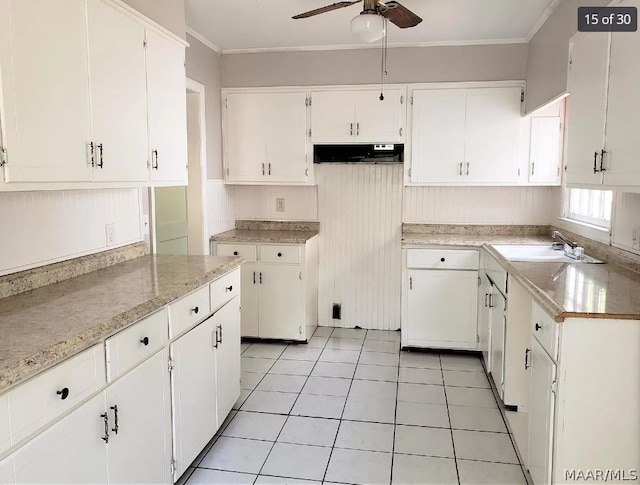 kitchen featuring ceiling fan, white cabinets, sink, and light tile patterned flooring